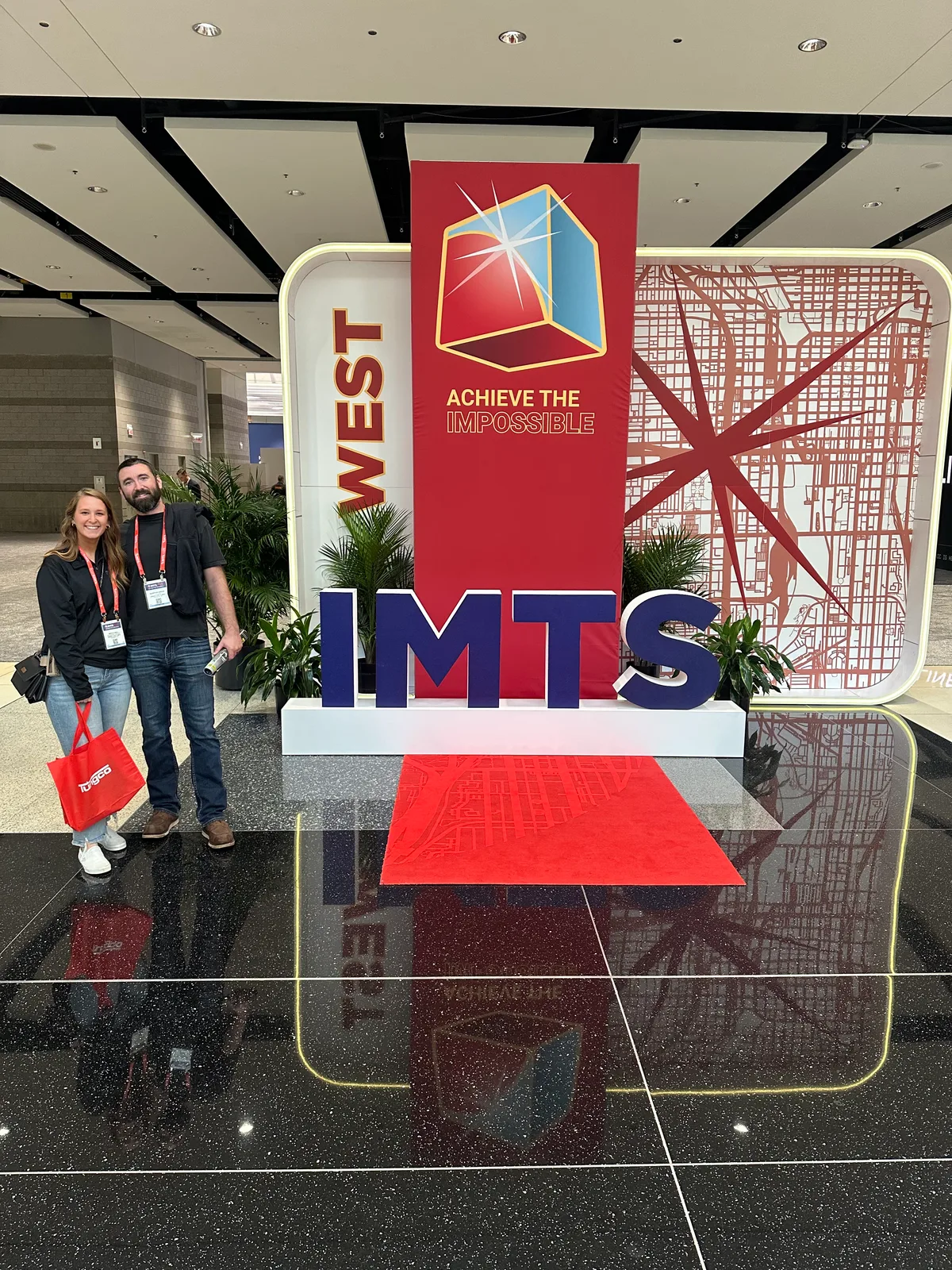 Zeman Tool team members beside the IMTS 2026 entrance display